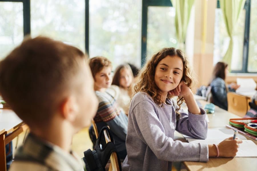 A Junior School teacher talking closely with a student