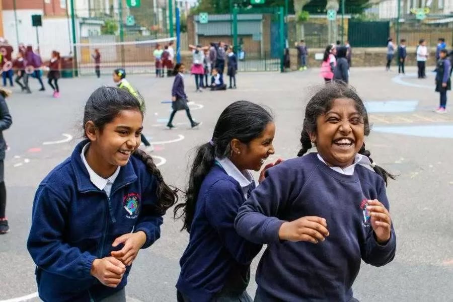 Junior School students laughing together on the playground